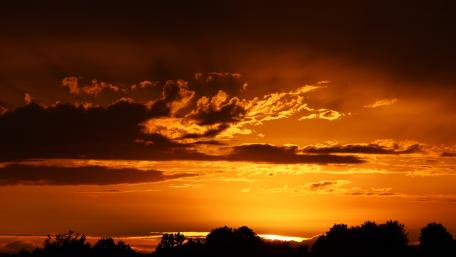 Vibrant Orange Sunset Over a Serene Horizon wallpaper
