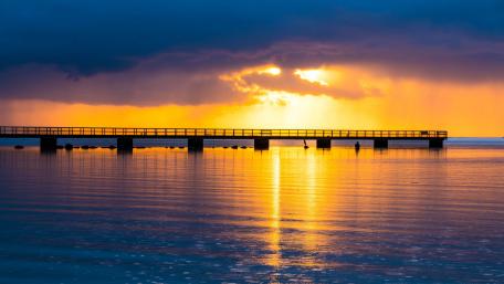 Golden Sunset Over Serene Pier Reflection in Water wallpaper