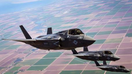Soaring F-35 Jets Over Patchwork Terrain wallpaper