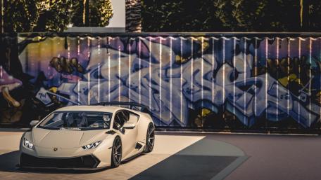 Sleek Lamborghini Huracan with Vibrant Graffiti Background wallpaper