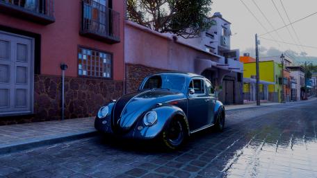 Classic Volkswagen Beetle in a Charming Street Scene wallpaper