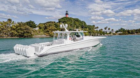Elegant Yacht Near Lighthouse Under Blue Skies wallpaper