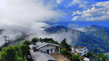 Breathtaking Mountain Retreat Under Dramatic Clouds wallpaper