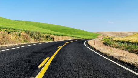 Winding Road Through Lush Green Hills wallpaper