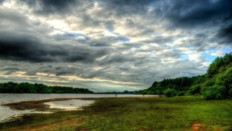 Tranquil River Landscape Under Dramatic Skies wallpaper