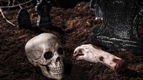 Skull and Hand in Eerie Graveyard Scene wallpaper
