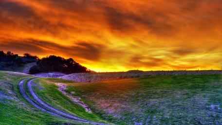 Vibrant Sunset Over Rolling Hills wallpaper