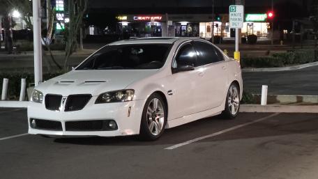 Sleek White Car Showcasing Stylish Design in Night Setting wallpaper