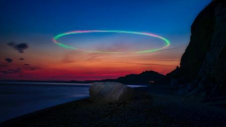 Ethereal Light Trails Over Dusk Shoreline wallpaper