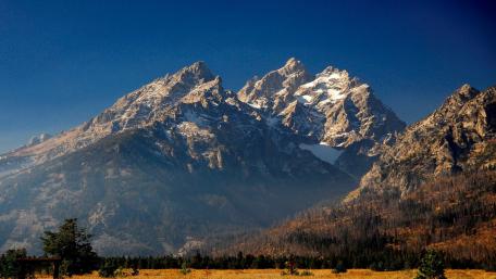 Majestic Mountain Peaks Against a Clear Blue Sky wallpaper