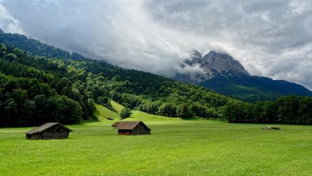 Serene Countryside Retreat Amidst Majestic Mountains wallpaper