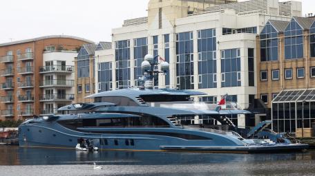 Luxury Superyacht Docked Near Urban Waterscape wallpaper