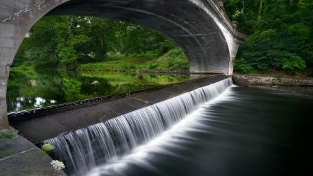 Serene Arch Bridge Over Tranquil River Scene wallpaper