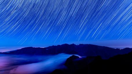 Starry Trails Over Misty Mountains wallpaper