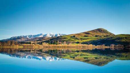 Serene Lake Reflection Under Clear Blue Skies wallpaper
