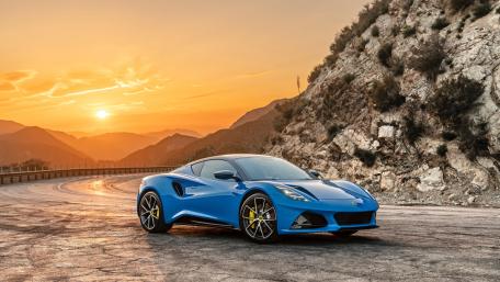 Sunset Drive with a Blue Lotus Emira Sports Car wallpaper