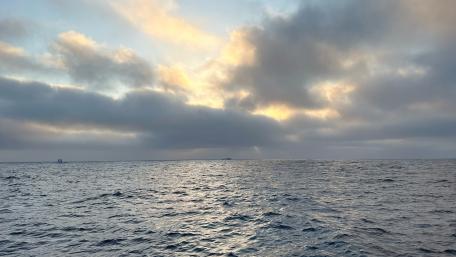 Serene Ocean at Dusk with Cloudy Skies wallpaper