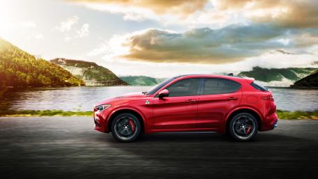 Dynamic Red Alfa Romeo Stelvio Quadrifoglio SUV Cruising Lakeside Road wallpaper