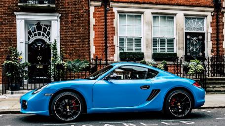Sleek Blue Porsche Cayman on Urban Street Scene wallpaper