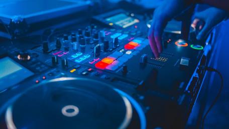 Dynamic DJ Mixer at Work Under Vibrant Lights wallpaper