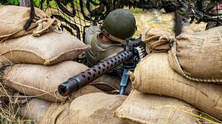 Soldier Behind Sandbags with Machine Gun Shielding Position wallpaper