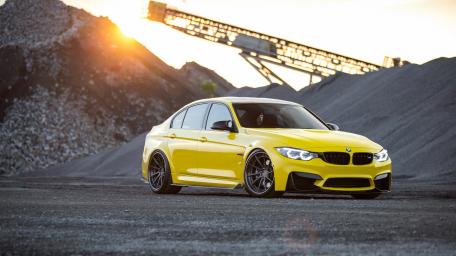 Dynamic Yellow BMW M4 in an Industrial Setting wallpaper