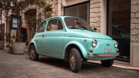 Charming Vintage Fiat 500 in Serene Setting wallpaper
