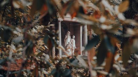 Serene Statue Surrounded by Nature Framing the Urban Landscape wallpaper