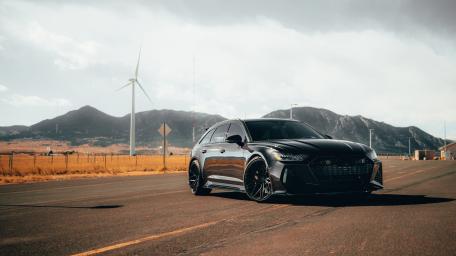 Sleek Black Car Against Scenic Landscape wallpaper