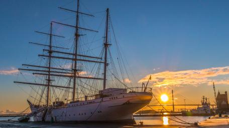 Majestic Sailing Ship at Sunset Harbor wallpaper