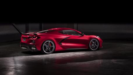 Sleek Red Chevrolet Corvette Stingray Sports Car in Shadowy Ambiance wallpaper