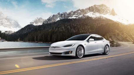 Sleek Tesla Driving Through Mountain Scenery wallpaper