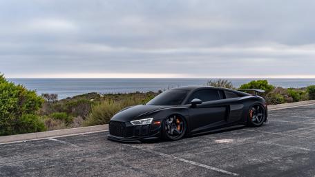 Sleek Black Sports Car Against Ocean Vista wallpaper