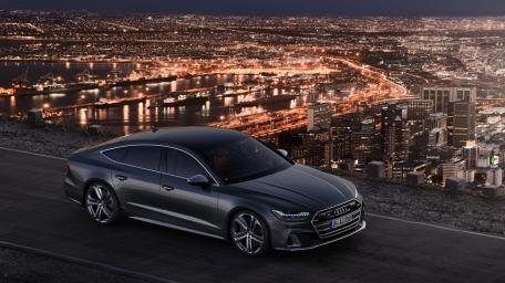 Luxury Sedan Overlooking Glimmering Cityscape wallpaper