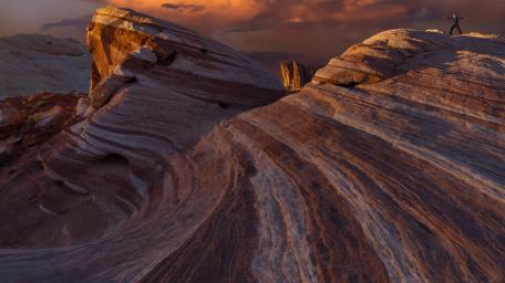 Desert Walker Amidst Crimson Dunes wallpaper