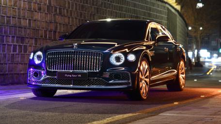 Midnight Majesty Luxurious Car in City Lights wallpaper