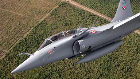 Soaring Rafale Rb 002 Military Jet Above Forested Terrain wallpaper