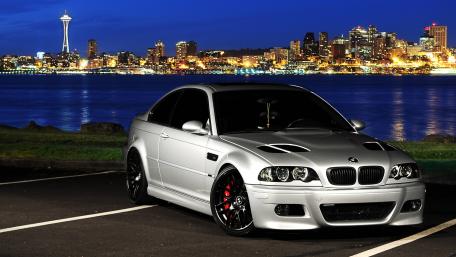 Sleek BMW M3 Against a City Skyline Night View wallpaper
