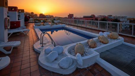 Rooftop Sunset Over Urban Horizon wallpaper