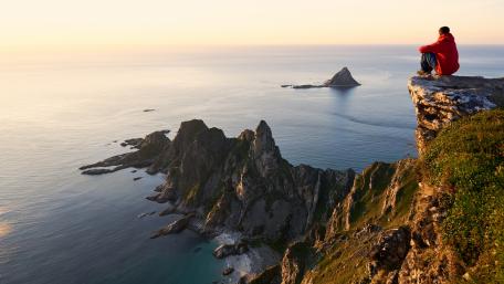 Man Overlooking Tranquil Seaside Cliffs wallpaper