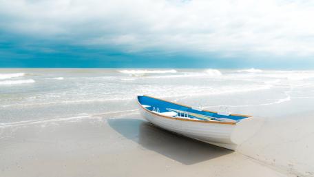 Solitary Boat on a Serene Sandy Beach wallpaper
