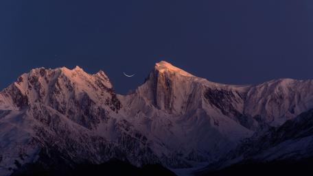 Majestic Crescent Over Snowy Peaks wallpaper