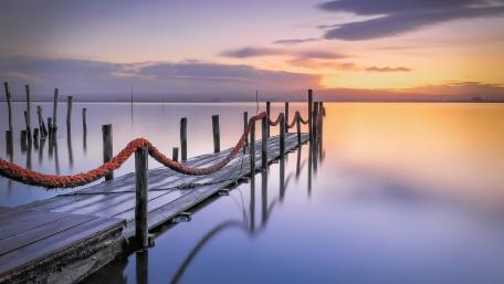 Serene Sunset Over Tranquil Lake Pier wallpaper