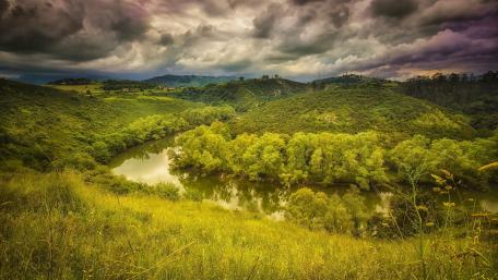 Curved River Under Cloudy Skies wallpaper