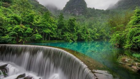 Serenity of Wolong Waterfall in Lush Greenery wallpaper