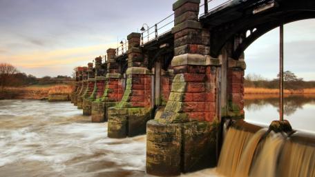 Timeless Stone Bridge Over River Rapids wallpaper