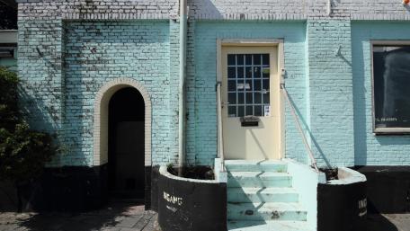 Charming Urban Facade with Vibrant Doorway and Brick Details wallpaper