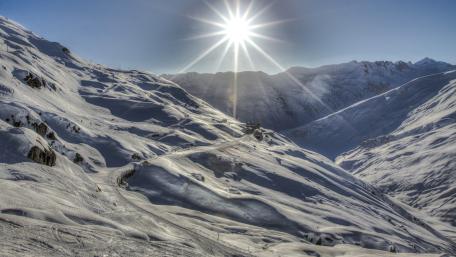 Winter Sunburst Over Snowy Alpine Peaks wallpaper