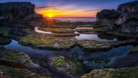 Sunset Serenity Over Rocky Shores wallpaper