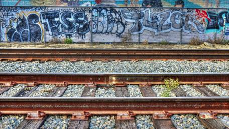 Urban Graffiti Meets Industrial Rails in Vibrant Scene wallpaper